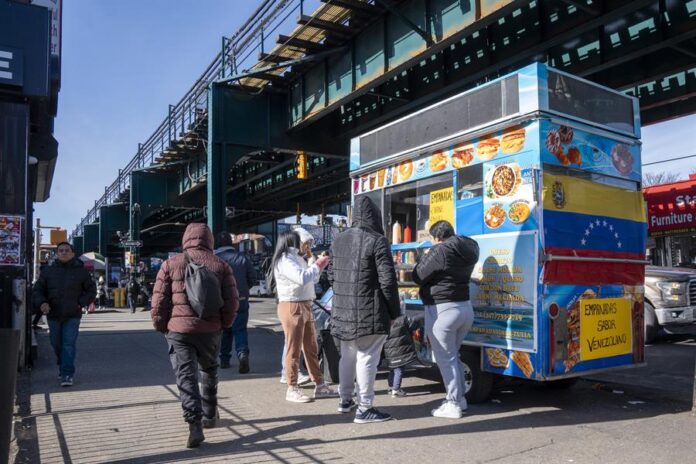 Personas consumen alimentos en un puesto de comida callejera este miércoles, en Queens Nueva York