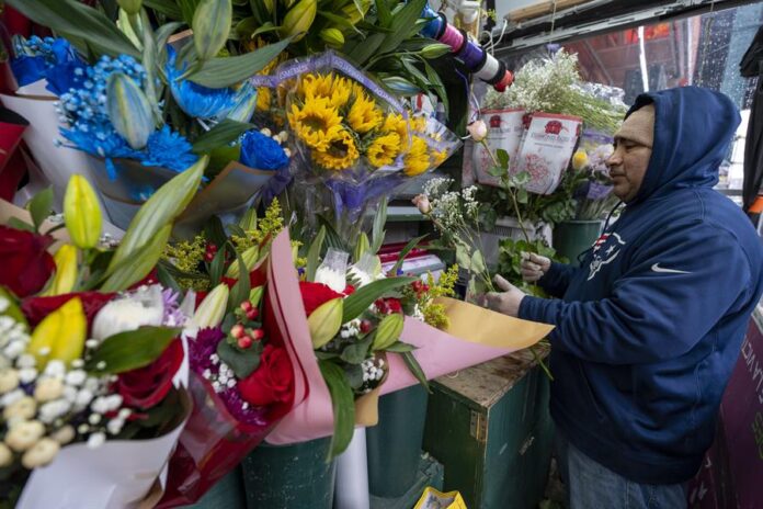 Un hombre prepara un ramo de flores durante los preparativos por el Día de San Valentín