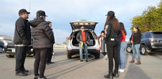 integrantes de la llamada 'Patrulla comunitaria' recibiendo instrucciones antes de salir en un recorrido por los barrios de familias inmigrantes
