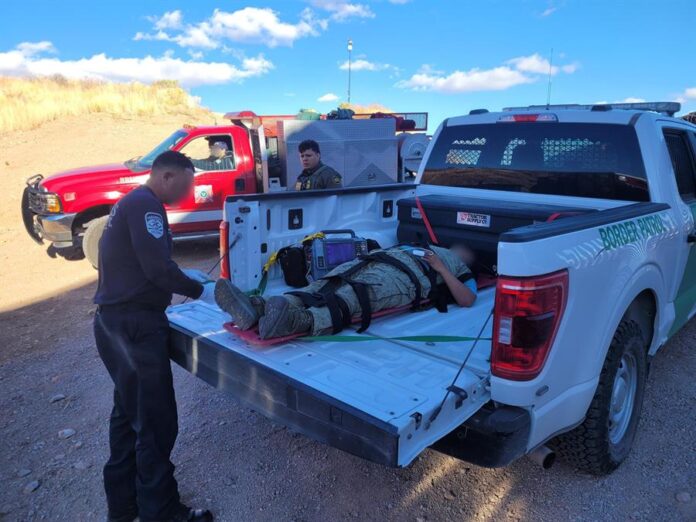 un agente mientras atiende a una mujer migrante que fue empujada por 'coyotes' en el muro fronterizo un agente mientras atiende a una mujer migrante que fue empujada por 'coyotes' en el muro fronterizo