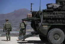 Un integrante del Ejército de Estados Unidos camina junto a un vehículo blindado 'Stryker' (1)