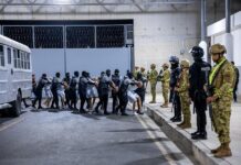Venezolanos repatriados de El Salvador piden garantías para acudir a audiencia en EE.UU. custodios del Centro del Confinamiento del Terrorismo (CECOT), trasladando a un grupo de detenidos provenientes de Estados Unidos (2)