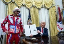 El presidente estadounidense Donald Trump (d) firma una orden ejecutiva junto al cantante Kid Rock