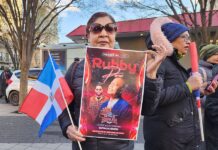 Una mujer sostiene un cartel del cantante Rubby Pérez durante una vigilia por las victimas del accidente en una discoteca de Santo Domingo