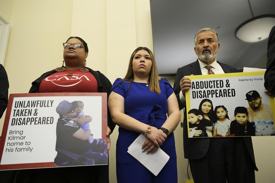 l congresista por California, el demócrata Juan Vargas (d), y una simpatizante (i), sostienen carteles junto a Jennifer Vásquez
