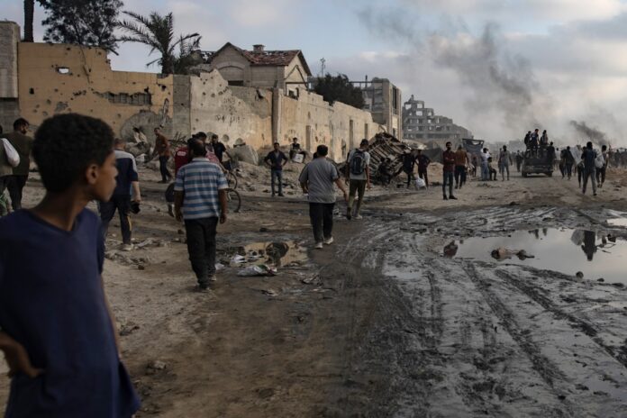 Displaced Palestinians carry relief parcels along Rashid Street, west of Gaza City bombardeos de Israel