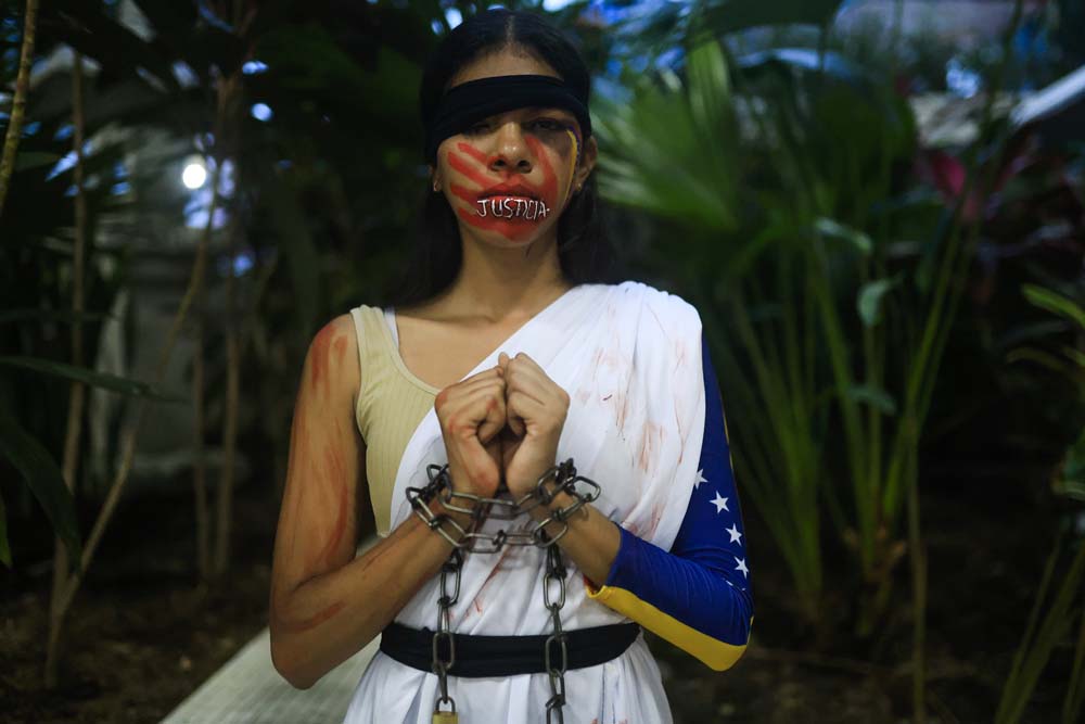 Una mujer participa en una representación artística durante el conversatorio 'VenezuelaMemoria y Justicia' este martes, en ciudad de Panamá, Panamá. La líder opositora venezolana María Corina Machado afirmó, en una intervención virtual durante un foro sobre Venezuela en Panamá, que "cada día que pasa se cierra el cerco" internacional contra el "cártel narcoterrorista que todavía sigue en Miraflores".