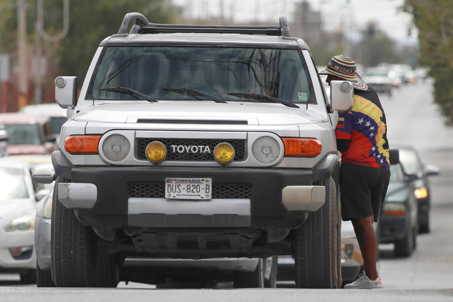 La migrante de Venezuela Eudis López ofrece mercancía a automovilistas este martes, en Ciudad Juárez