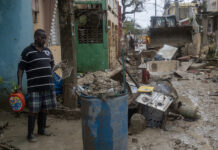 Personas observan una calle afectada por el huracán Melissa