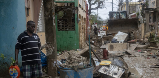Personas observan una calle afectada por el huracán Melissa