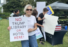 Personas sostienen carteles en una protesta contra la futura biblioteca del presidente de los Estados Unidos, Donald Trump