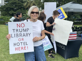 Personas sostienen carteles en una protesta contra la futura biblioteca del presidente de los Estados Unidos, Donald Trump