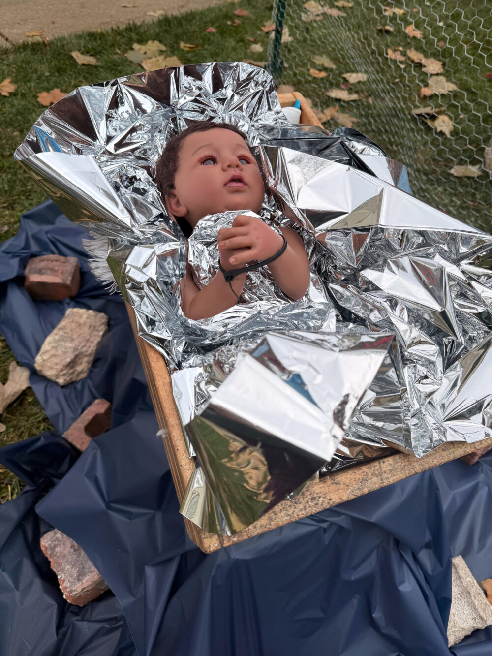 Ni&ntilde;o Jes&uacute;s en una caja con las manos atadas y cubierto por una manta de papel de aluminio
