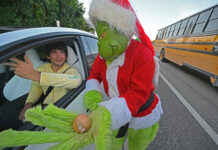 coronel retirado Lou Caputo, disfrazado del Grinch (d), ofreciendo una cebolla a una persona que conducía con un ligero exceso de velocidad