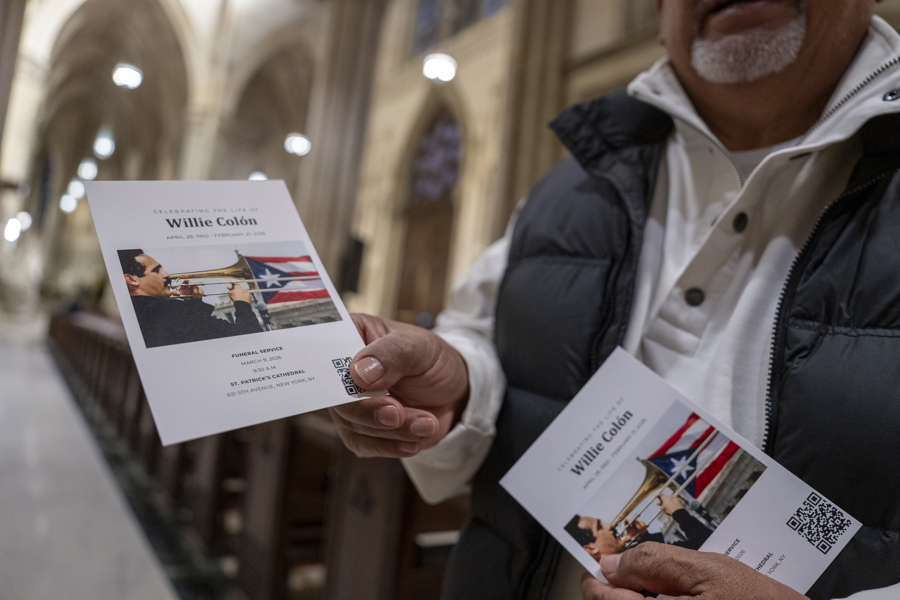Un hombre sostiene una tarjeta durante la misa p&uacute;blica del fallecido cantante Willie Col&oacute;n