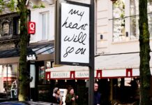 Posters featuring Celine Dion song titles appear in Paris