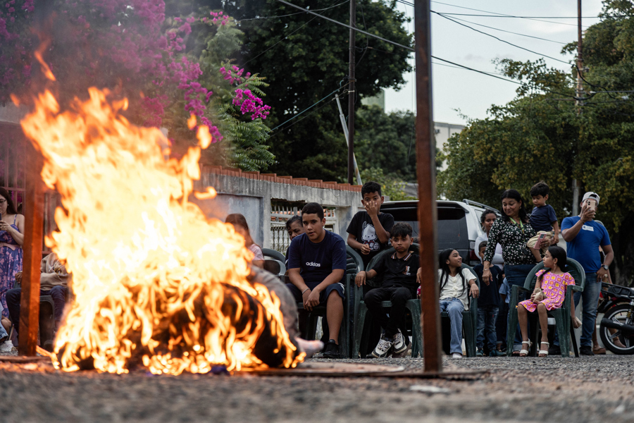  Personas observan a un mu&ntilde;eco de Judas quem&aacute;ndose este domingo, en Maracaibo 