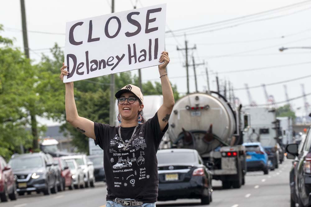 Una persona sostiene un cartel frente al centro de detenci&oacute;n de inmigrantes DelaneyHall en Nueva Jersey.
