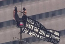 Dos personas suben a la cima del Empire State Building con una pancarta a favor de la paz