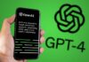 Hand holding a phone with the OpenAI GPT-4 website on the screen