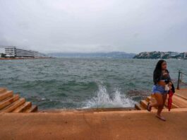El huracán Vance baja a categoría 1 y se localiza frente a costas de Michoacán y Guerrero turista en el malecón de Acapulco